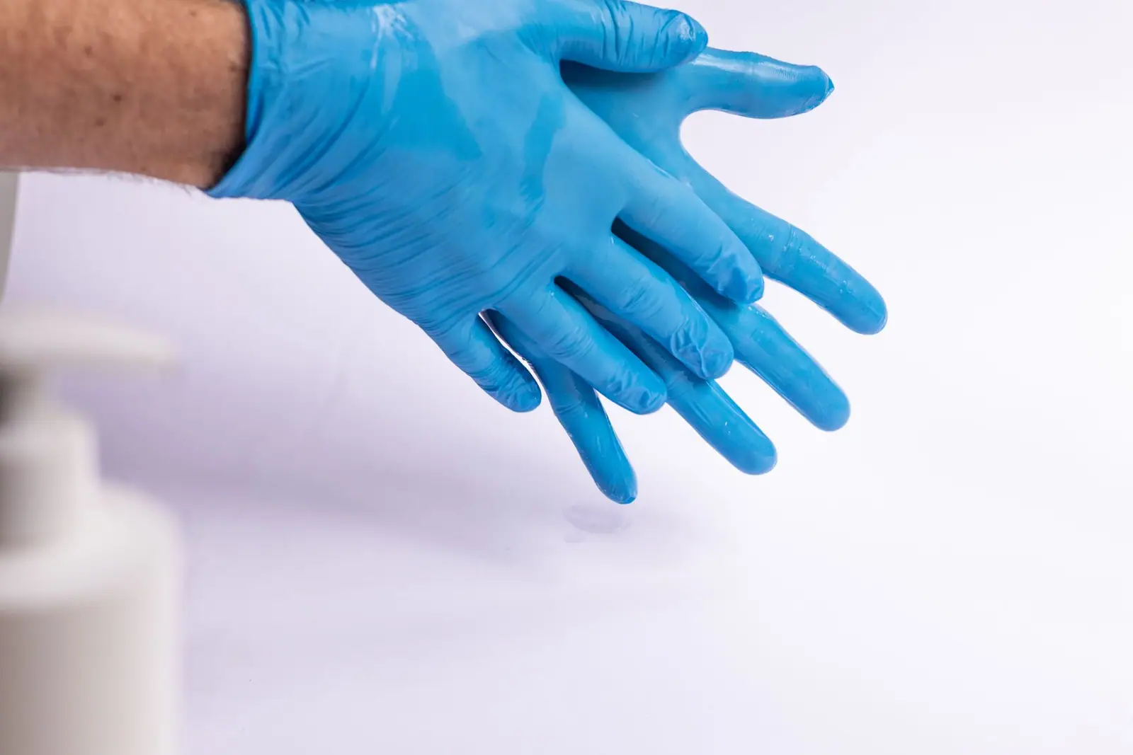 A hand in a blue disposable glove